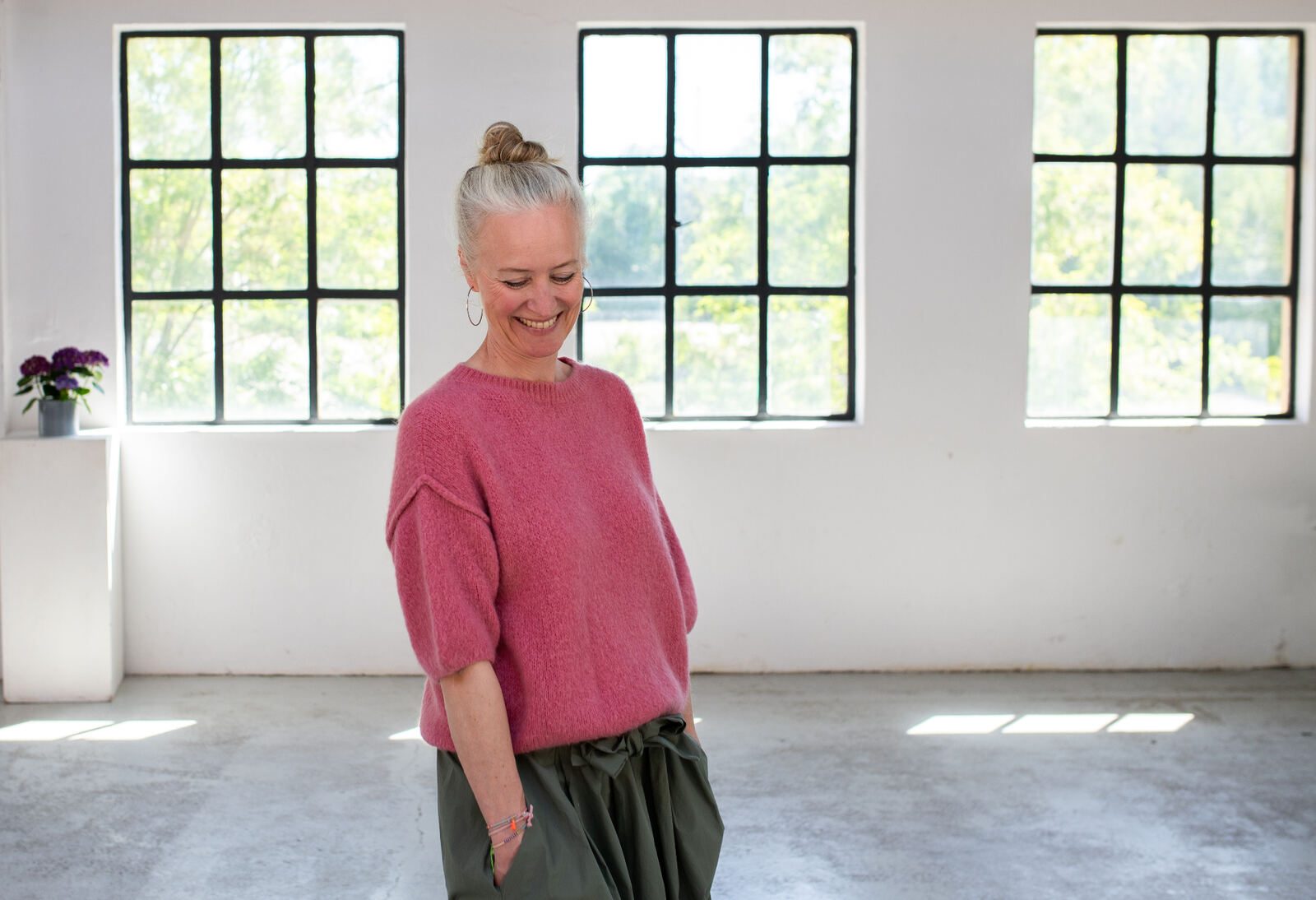 Sonja Klein im rosa Pullover vor Atelierfenstern